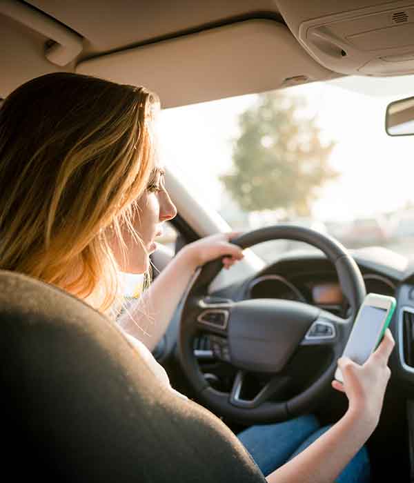 woman driving while using cell phone